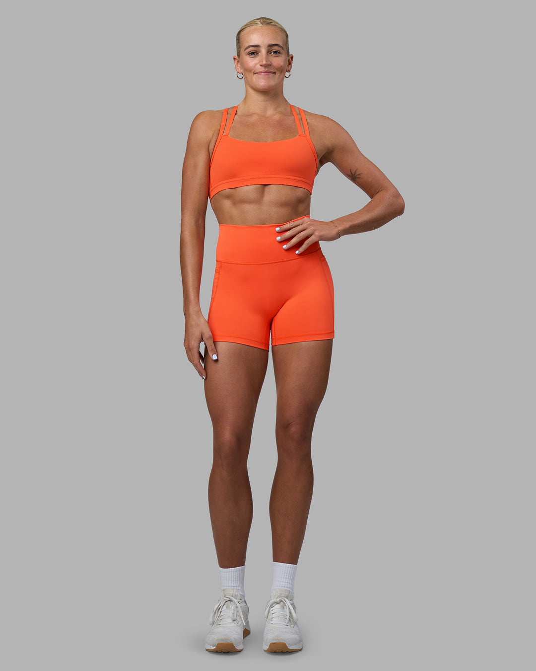 Woman wearing Velocity Sports Bra - Ultra Orange | Model:Katie | Size:S