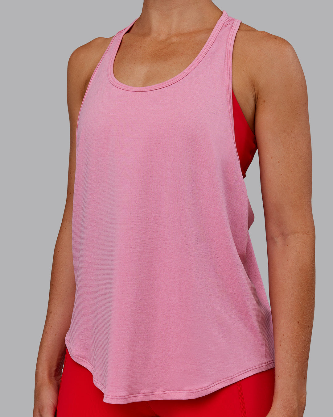 Woman wearing AeroFLX+ Drop Armhole Seamless Tank - Candy Pink | Model:Paris | Size:S