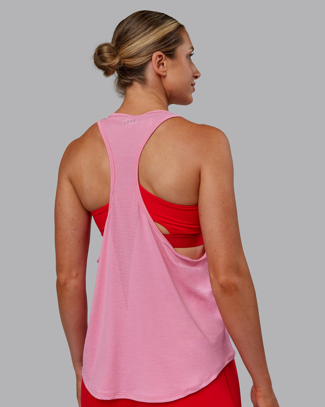 Woman wearing AeroFLX+ Drop Armhole Seamless Tank - Candy Pink | Model:Paris | Size:S