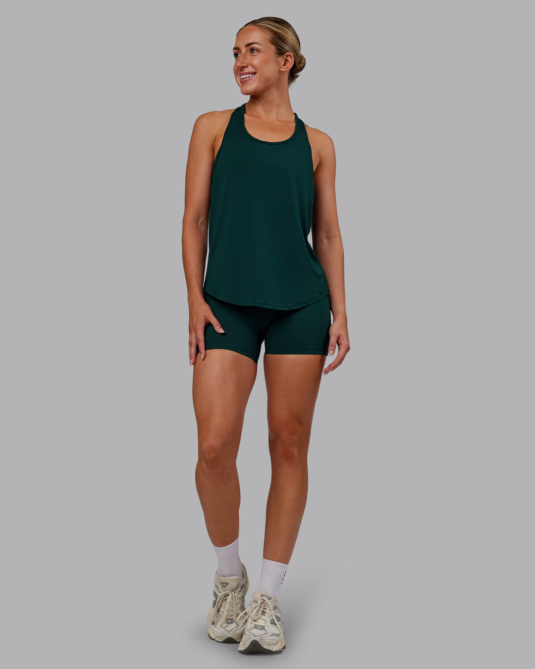 Woman wearing AeroFLX+ Drop Armhole Seamless Tank - Dark Moss | Model:Paris | Size:S