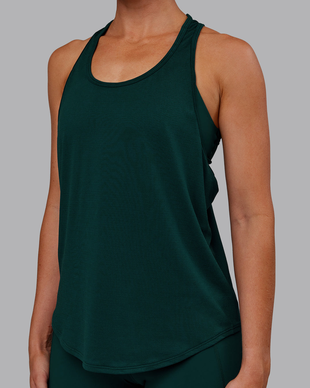 Woman wearing AeroFLX+ Drop Armhole Seamless Tank - Dark Moss | Model:Paris | Size:S