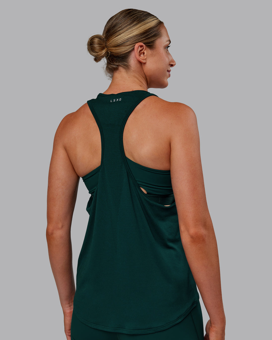 Woman wearing AeroFLX+ Drop Armhole Seamless Tank - Dark Moss | Model:Paris | Size:S