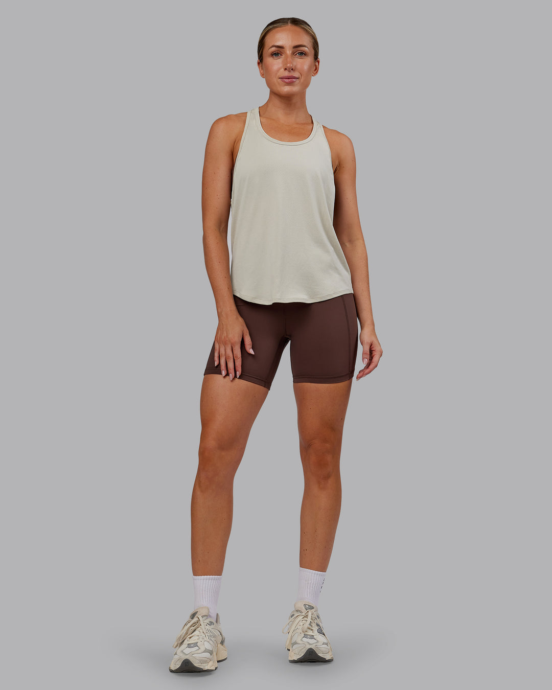 Woman wearing AeroFLX+ Drop Armhole Seamless Tank - Shale Beige | Model:Paris | Size:S