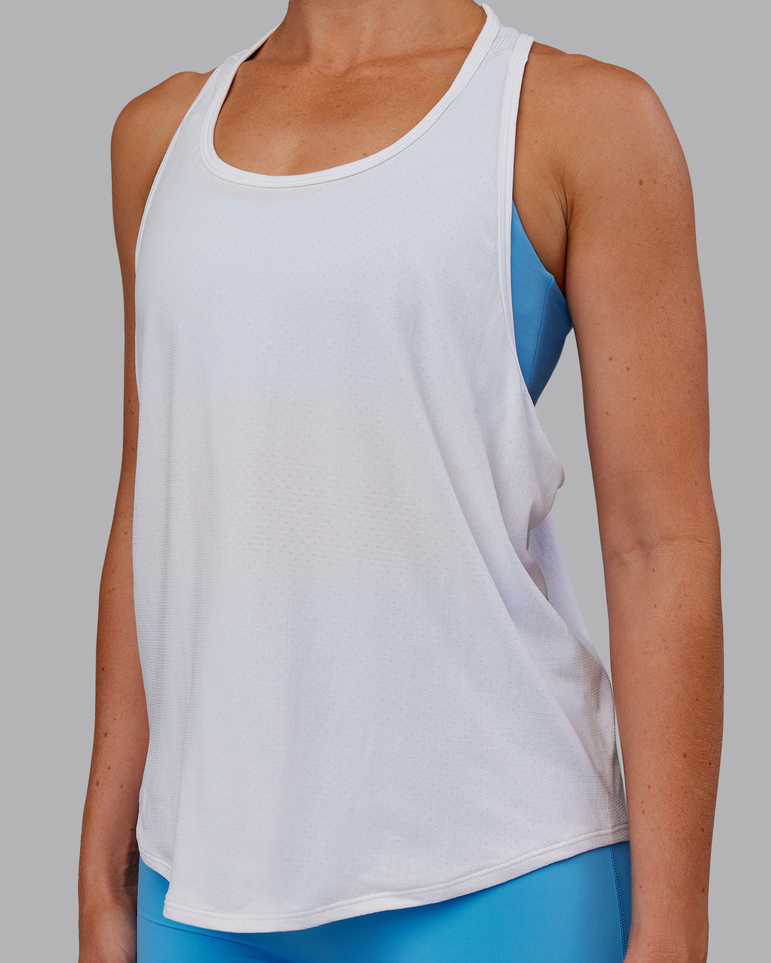 Woman wearing AeroFLX+ Drop Armhole Seamless Tank - White | Model:Paris | Size:S