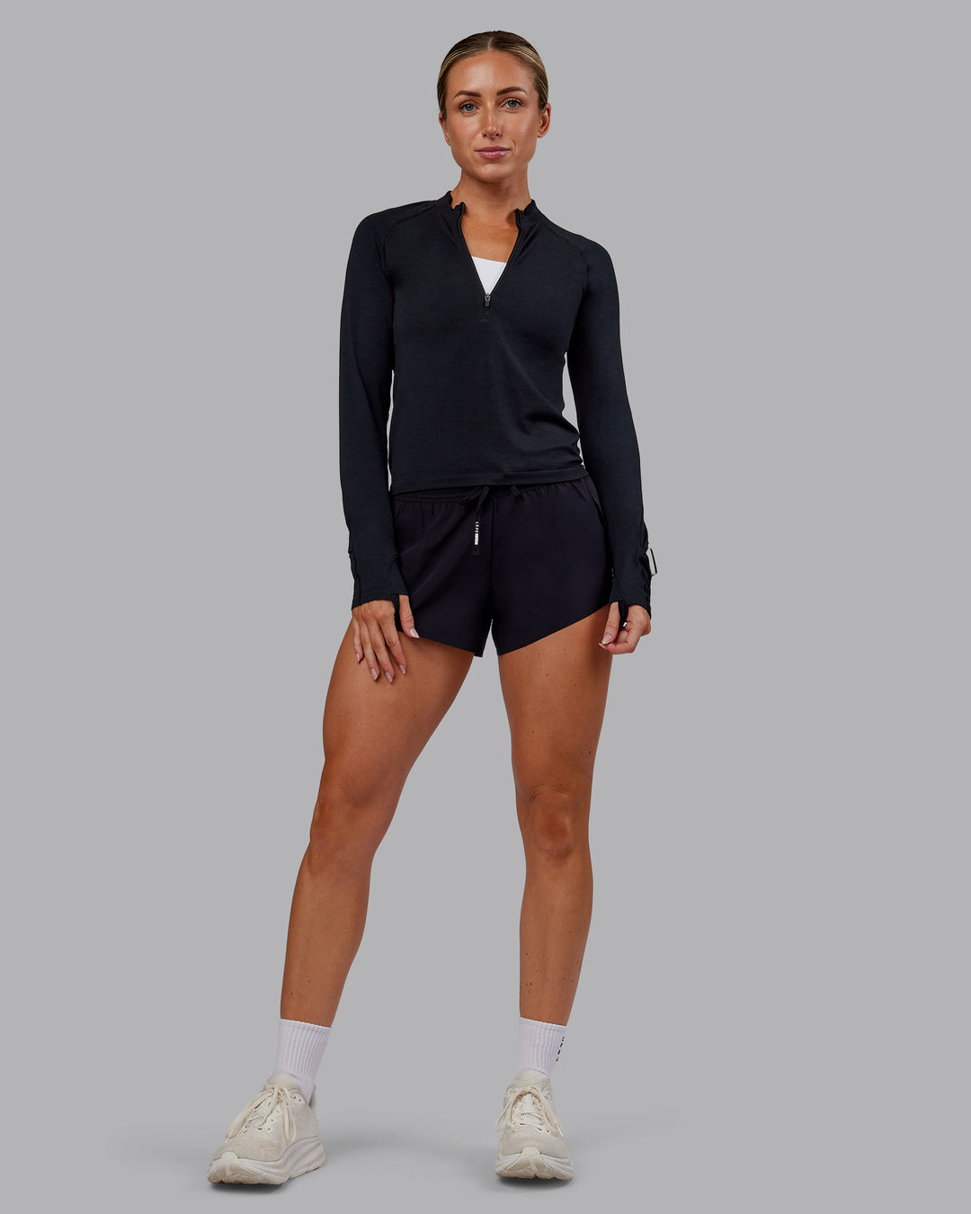 Woman wearing AeroFLX+ Long Sleeve Half Zip - Black Marl | Model:Paris | Size:S