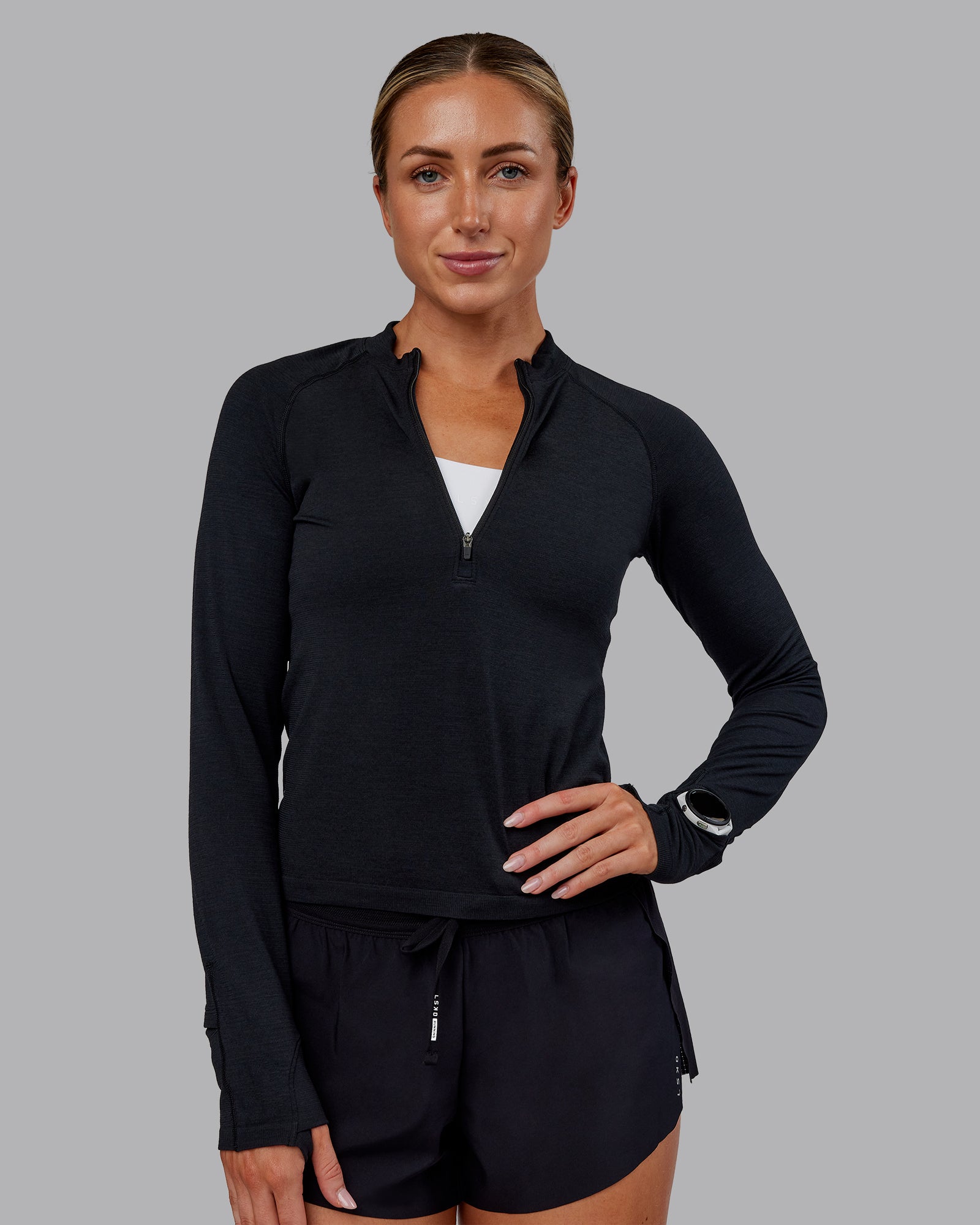Woman wearing AeroFLX+ Long Sleeve Half Zip - Black Marl | Model:Paris | Size:S