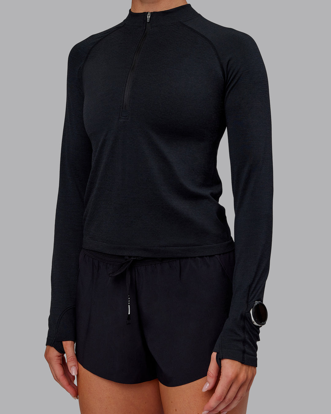 Woman wearing AeroFLX+ Long Sleeve Half Zip - Black Marl | Model:Paris | Size:S