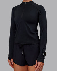 Woman wearing AeroFLX+ Long Sleeve Half Zip - Black Marl | Model:Paris | Size:S