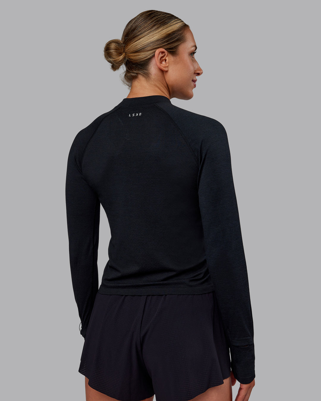 Woman wearing AeroFLX+ Long Sleeve Half Zip - Black Marl | Model:Paris | Size:S