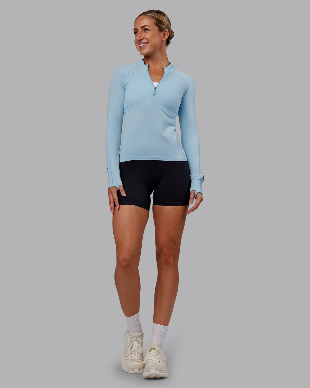 Woman wearing AeroFLX+ Long Sleeve Half Zip - Glacial Blue/Glacial Blue | Model:Paris | Size:S