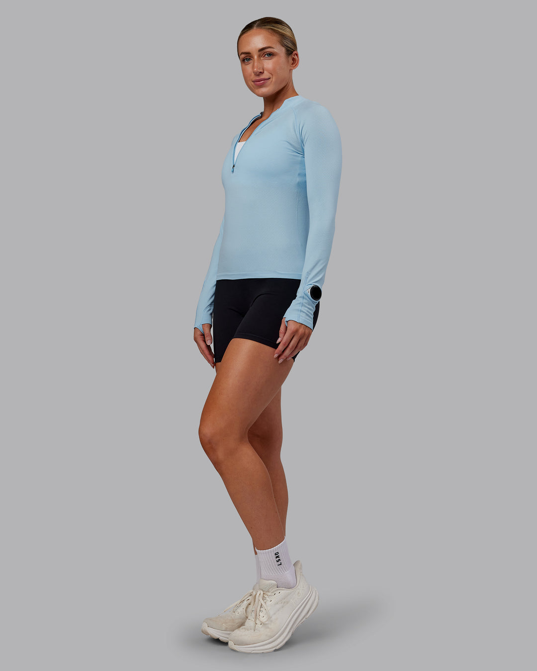 Woman wearing AeroFLX+ Long Sleeve Half Zip - Glacial Blue/Glacial Blue | Model:Paris | Size:S
