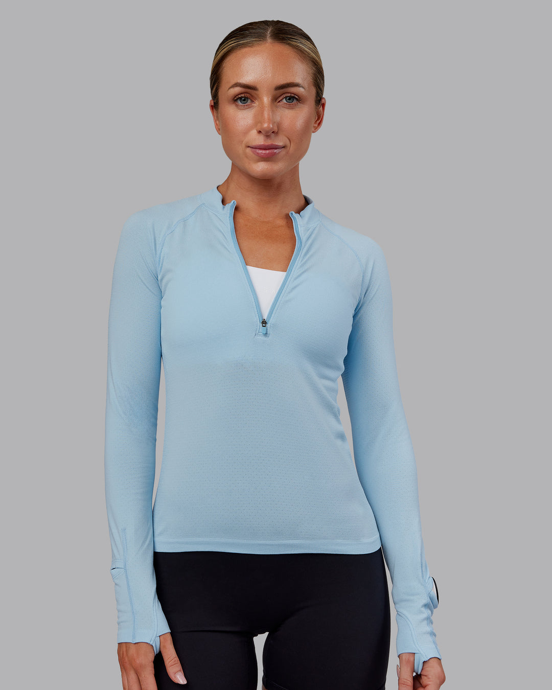 Woman wearing AeroFLX+ Long Sleeve Half Zip - Glacial Blue/Glacial Blue | Model:Paris | Size:S