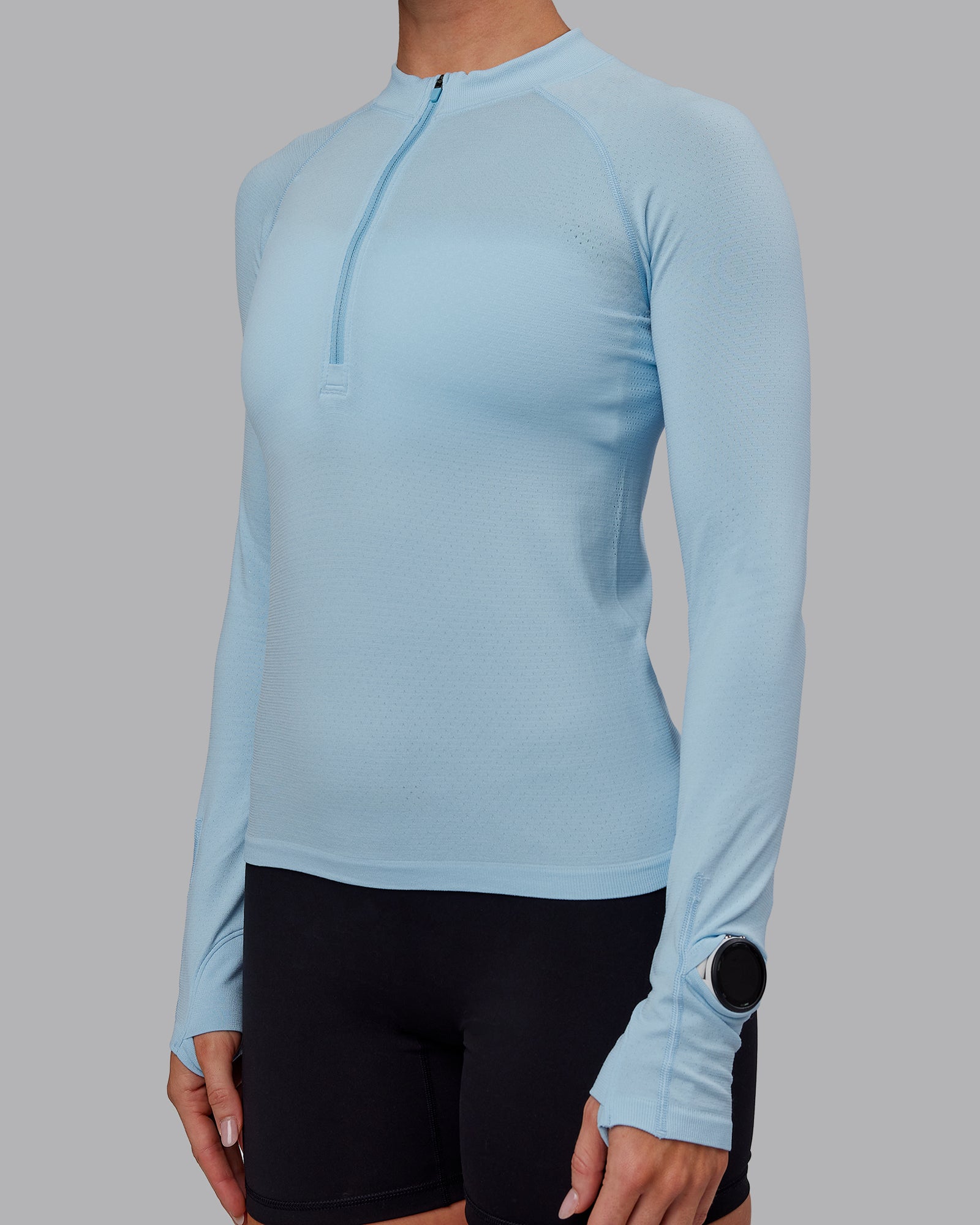Woman wearing AeroFLX+ Long Sleeve Half Zip - Glacial Blue/Glacial Blue | Model:Paris | Size:S