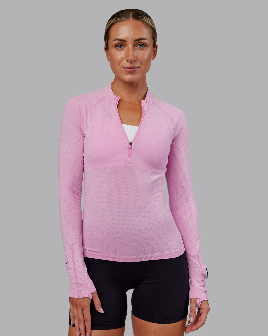 Woman wearing AeroFLX+ Long Sleeve Half Zip - Bubblegum/Pirouette | Model:Paris | Size:S