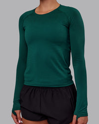 Woman wearing AeroFLX+ Seamless Long Sleeve Tee - Dark Moss/Dark Moss | Model:Charlize | Size:S