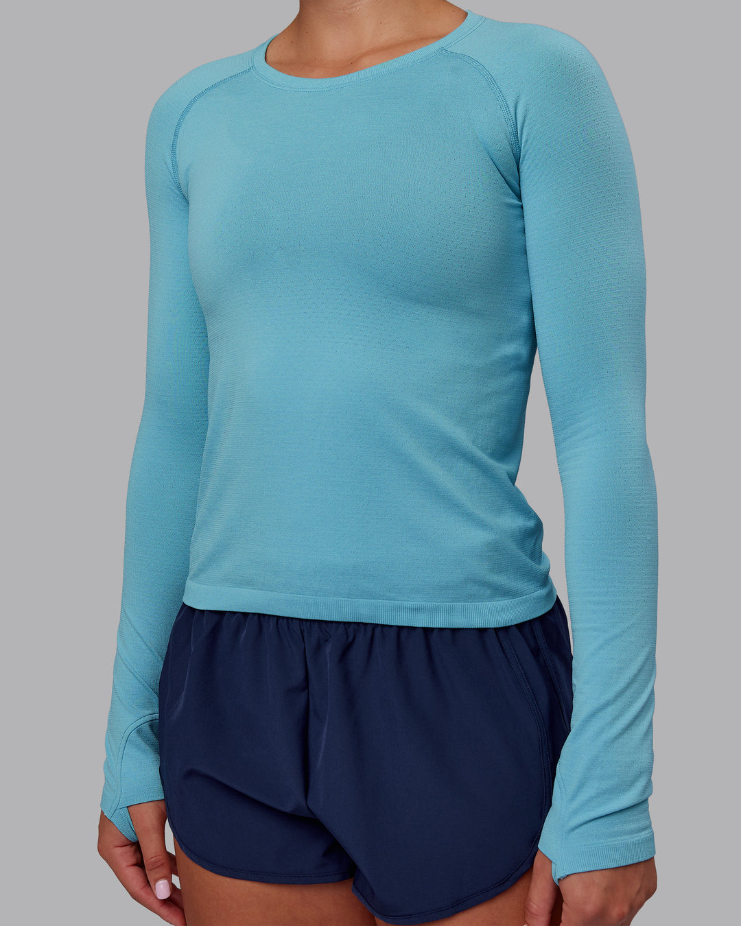 Woman wearing AeroFLX+ Seamless Long Sleeve Tee - Retro Blue/Retro Blue | Model:Charlize | Size:S
