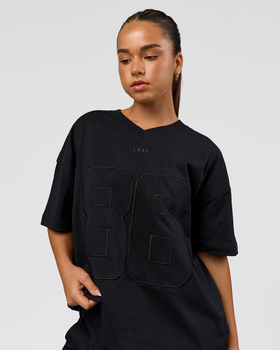 Woman wearing 86 V-Neck Oversized Tee - Black-Black | Model:Sophia | Size:S 