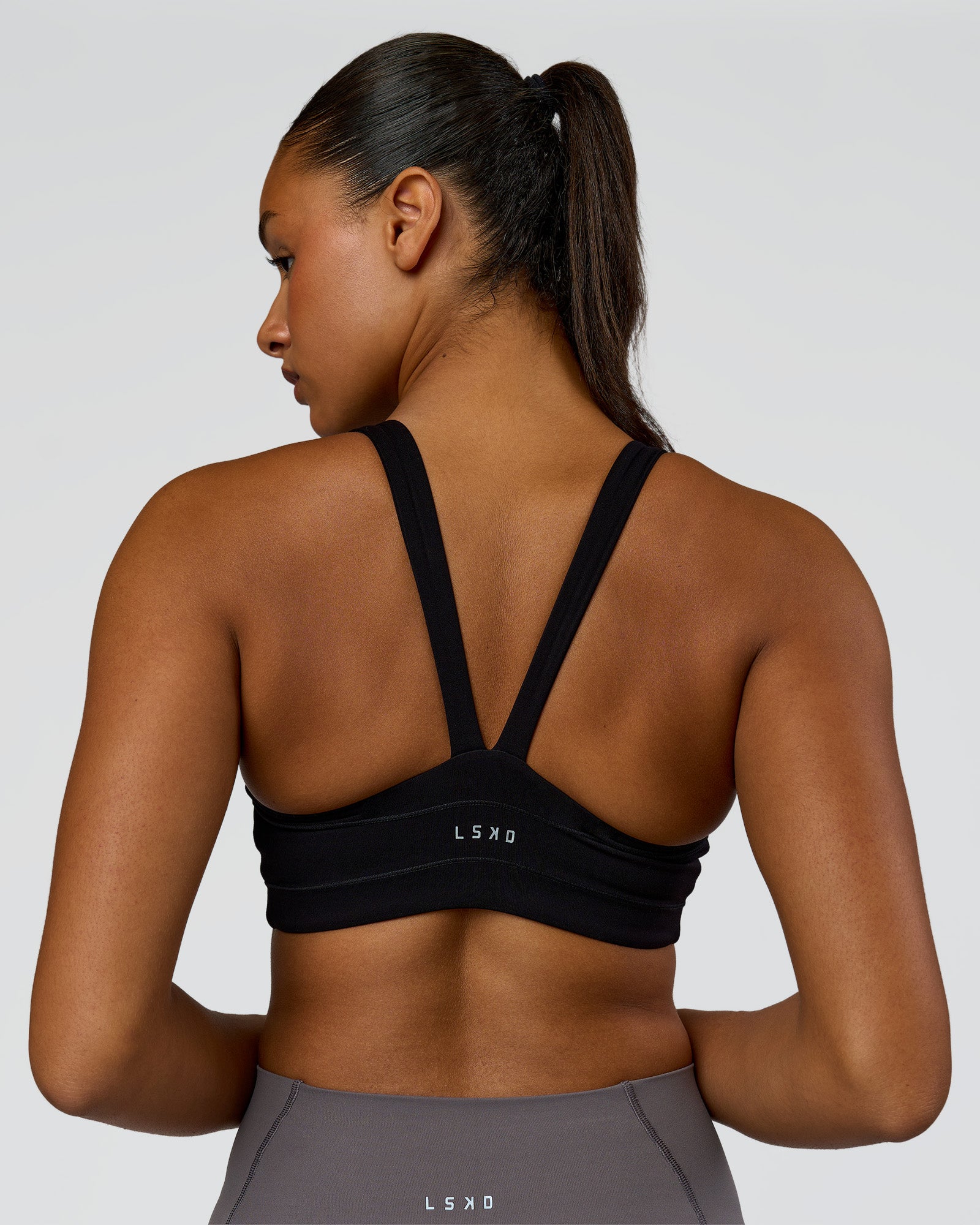 Woman wearing Inertia Sports Bra - Black | Model:Rosie | Size:S