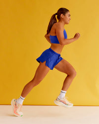 Woman wearing Accelerate 3" Mid-Rise Running Short - Electric Indigo | Set:true | Angle:closeup | Model:Bella | Size:XS