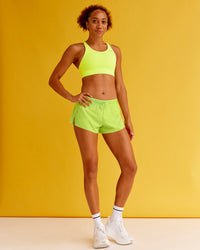 Woman wearing Accelerate 3" Mid-Rise Running Short - Hyper Green | Model:Txai | Size:XS