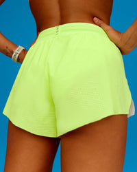 Woman wearing Accelerate 3" Running Short - Lime Glo-Shale Beige | Model:Steph | Size:XS