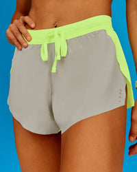 Woman wearing Accelerate 3" Running Short - Lime Glo-Shale Beige | Model:Steph | Size:XS