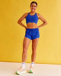 Woman wearing Accelerate Split Strap Sports Bra - Electric Indigo | Model:Bella | Size:XS