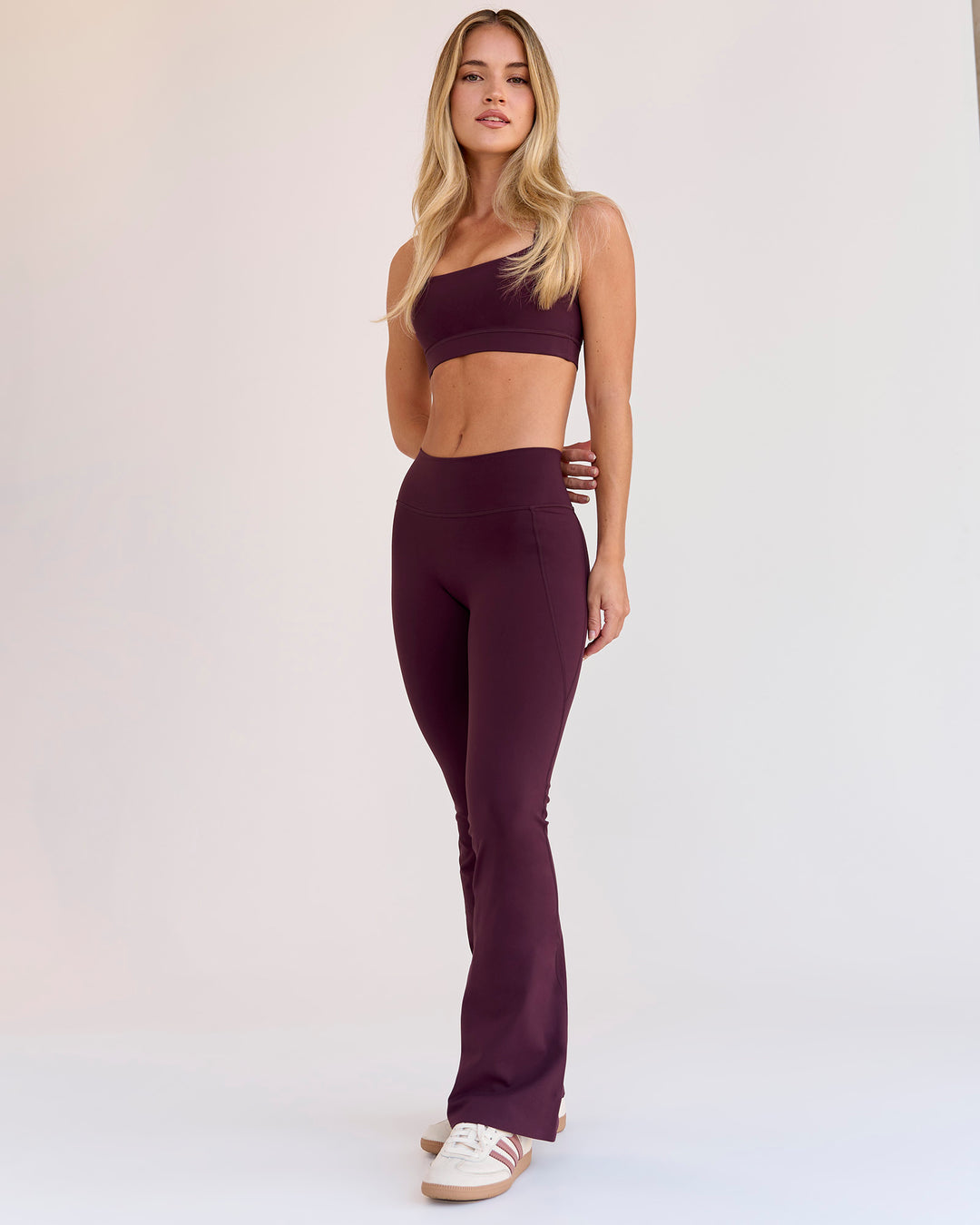 Woman wearing Fusion V-Contour High-Rise Flared Petite Legging Pockets - Cherry Lacquer | Model:Issy | Size:XS