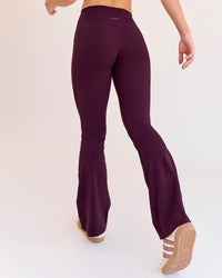 Woman wearing Fusion V-Contour High-Rise Flared Petite Legging Pockets - Cherry Lacquer | Model:Issy | Size:XS