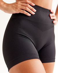 Woman wearing Surge Seamless High-Rise 4" Short - Black | Model:Brylee | Size:XS