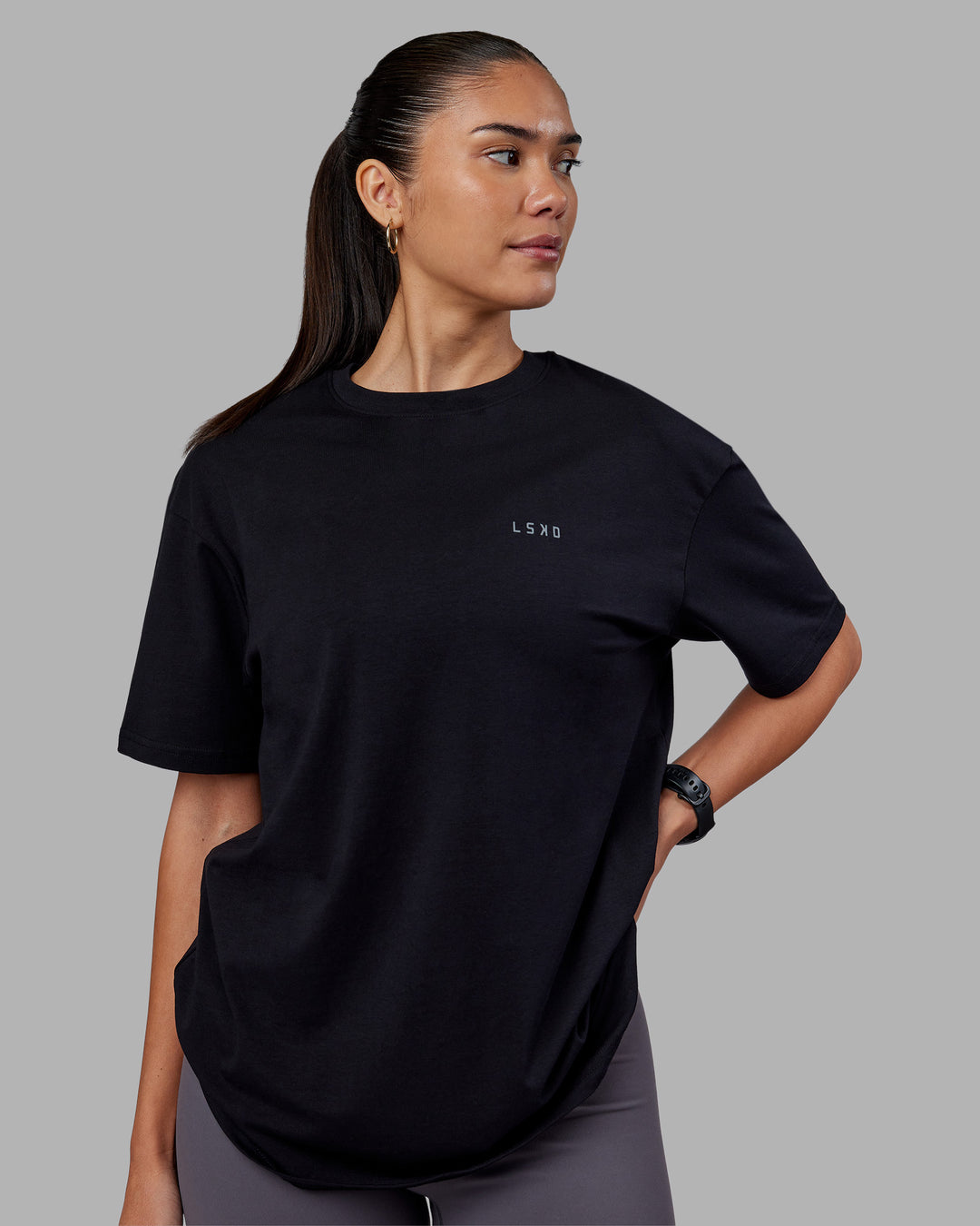 Woman wearing 1% Better Value Series FLXCotton Tee Oversize - Black-Black | Model:Rhiley | Size:XS