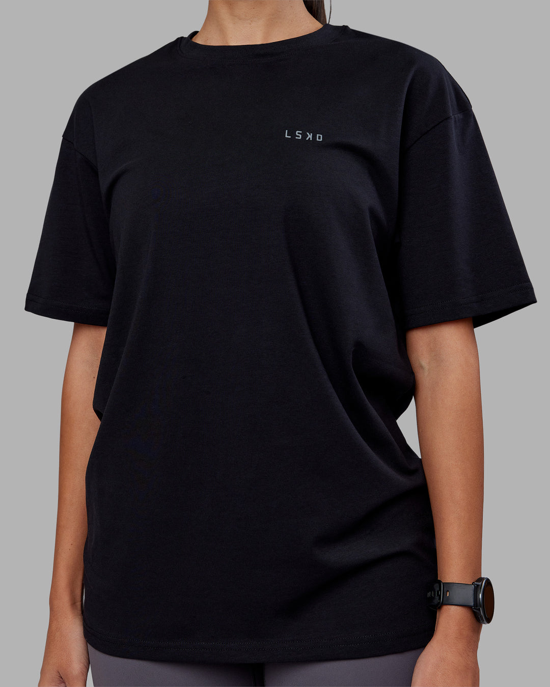 Woman wearing 1% Better Value Series FLXCotton Tee Oversize - Black-Black | Model:Rhiley | Size:XS