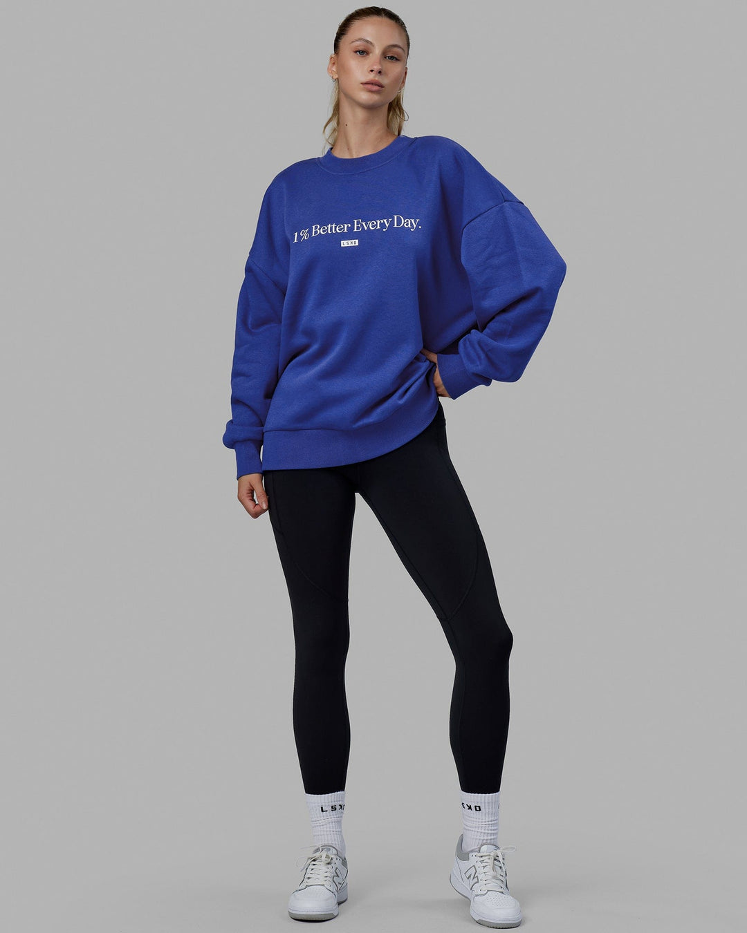 Woman wearing Unisex 1% Better Sweater Oversize - Power Cobalt-White