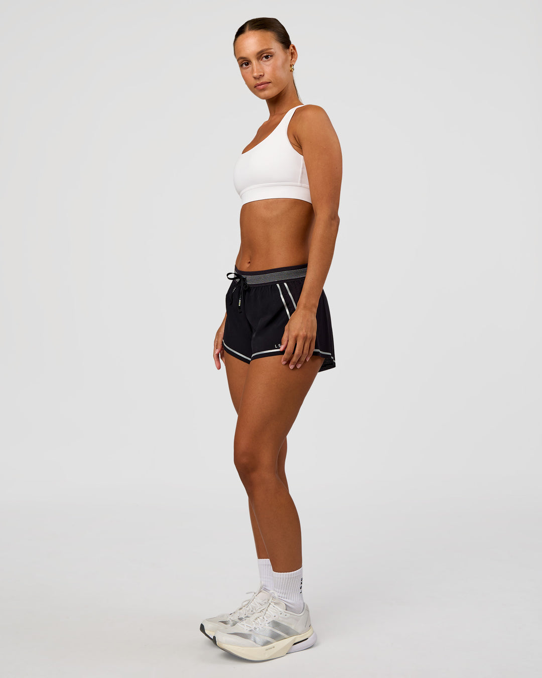 Woman wearing Accelerate 3" Reflective Mid-Rise Running Short - Black-Reflective | Model:Brylee | Size:XS