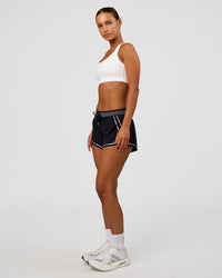 Woman wearing Accelerate 3" Reflective Mid-Rise Running Short - Black-Reflective | Model:Brylee | Size:XS