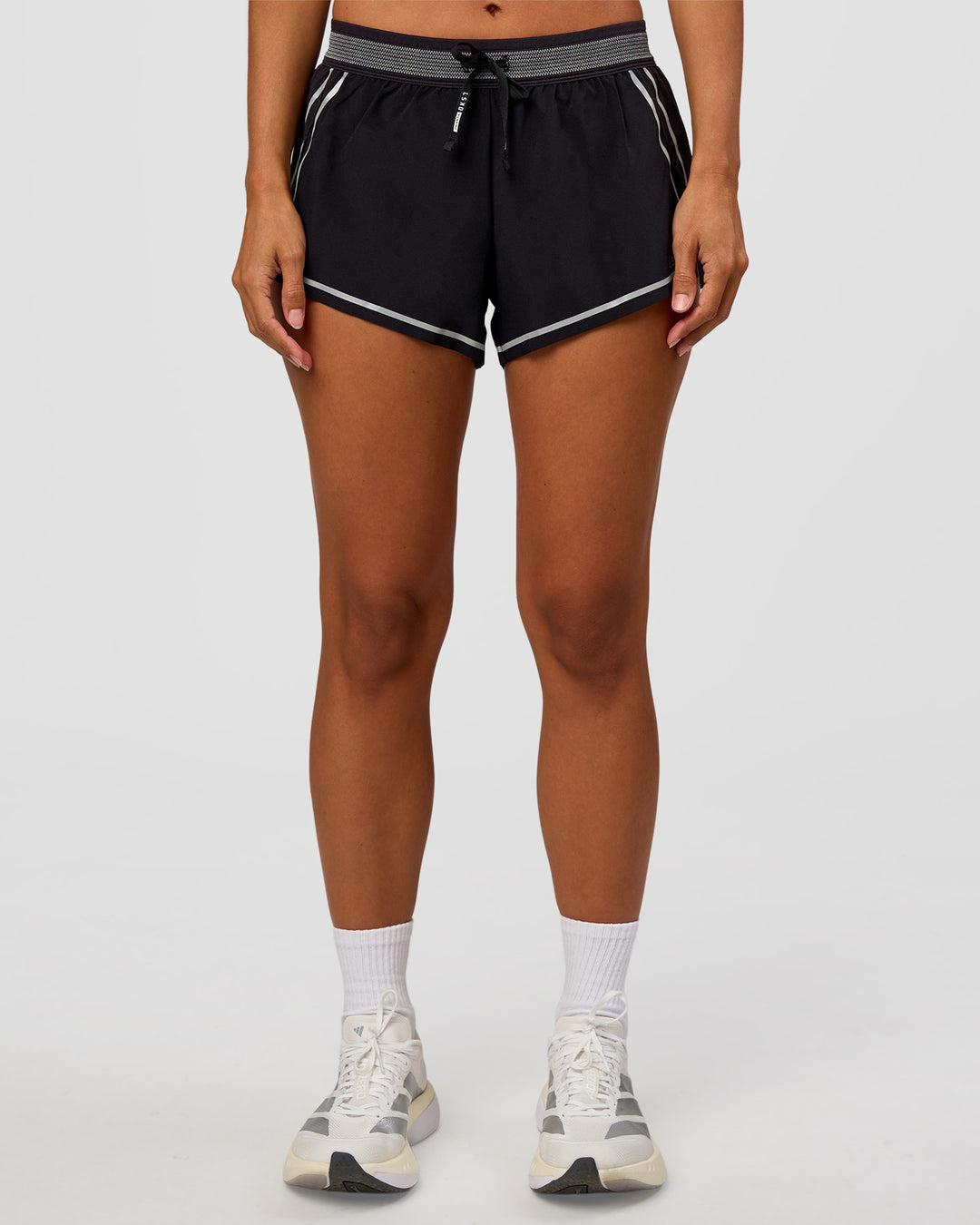 Woman wearing Accelerate 3" Reflective Mid-Rise Running Short - Black-Reflective | Set:true | Angle:front | Model:Brylee | Size:XS
