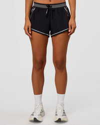 Woman wearing Accelerate 3" Reflective Mid-Rise Running Short - Black-Reflective | Set:true | Angle:front | Model:Brylee | Size:XS
