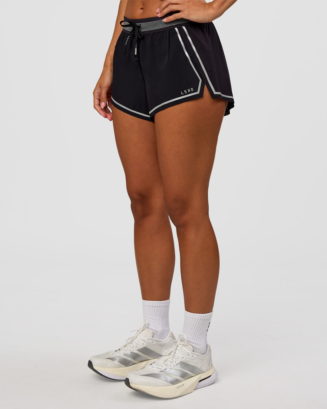 Woman wearing Accelerate 3" Reflective Mid-Rise Running Short - Black-Reflective | Set:true | Angle:side | Model:Brylee | Size:XS