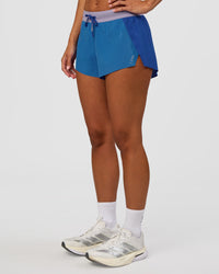 Woman wearing Accelerate 3" Mid-Rise Running Short - Electric Indigo-Multi | Set:true | Angle:side | Model:Brylee | Size:XS