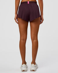 Woman wearing Accelerate 3" Mid-Rise Running Short - Midnight Plum-Sugar Plum | Set:True | Angle:back | Model:Charli | Size:XS