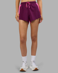 Woman wearing Accelerate 3" High-Rise Running Short - Ultra Pink-Plum Caspia | Set:true | Angle:front | Model:Leilani | Size:XS