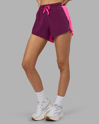 Woman wearing Accelerate 3" High-Rise Running Short - Ultra Pink-Plum Caspia | Set:true | Angle:side | Model:Leilani | Size:XS