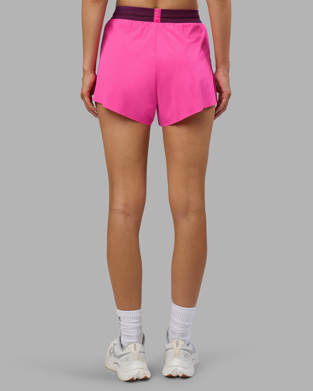 Woman wearing Accelerate 3" High-Rise Running Short - Ultra Pink-Plum Caspia | Set:true | Angle:back | Model:Leilani | Size:XS