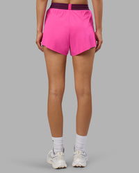 Woman wearing Accelerate 3" High-Rise Running Short - Ultra Pink-Plum Caspia | Set:true | Angle:back | Model:Leilani | Size:XS