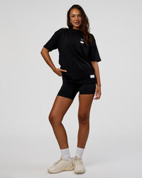 Woman wearing Archive FLXCotton Oversized Tee - Black-Open Air | Model:Kirstyn | Size:XS