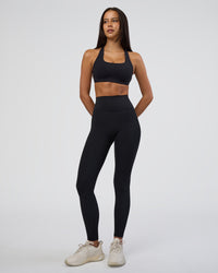 Woman wearing Aspire Sports Bra - Black | Model:Eliza | Size:XS