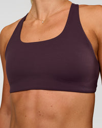 Woman wearing Aspire Sports Bra - Midnight Plum | Model:Emelia | Size:XS
