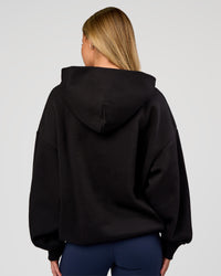 Woman wearing Base Oversized Hoodie - Black | Model:Issy | Size:XS |