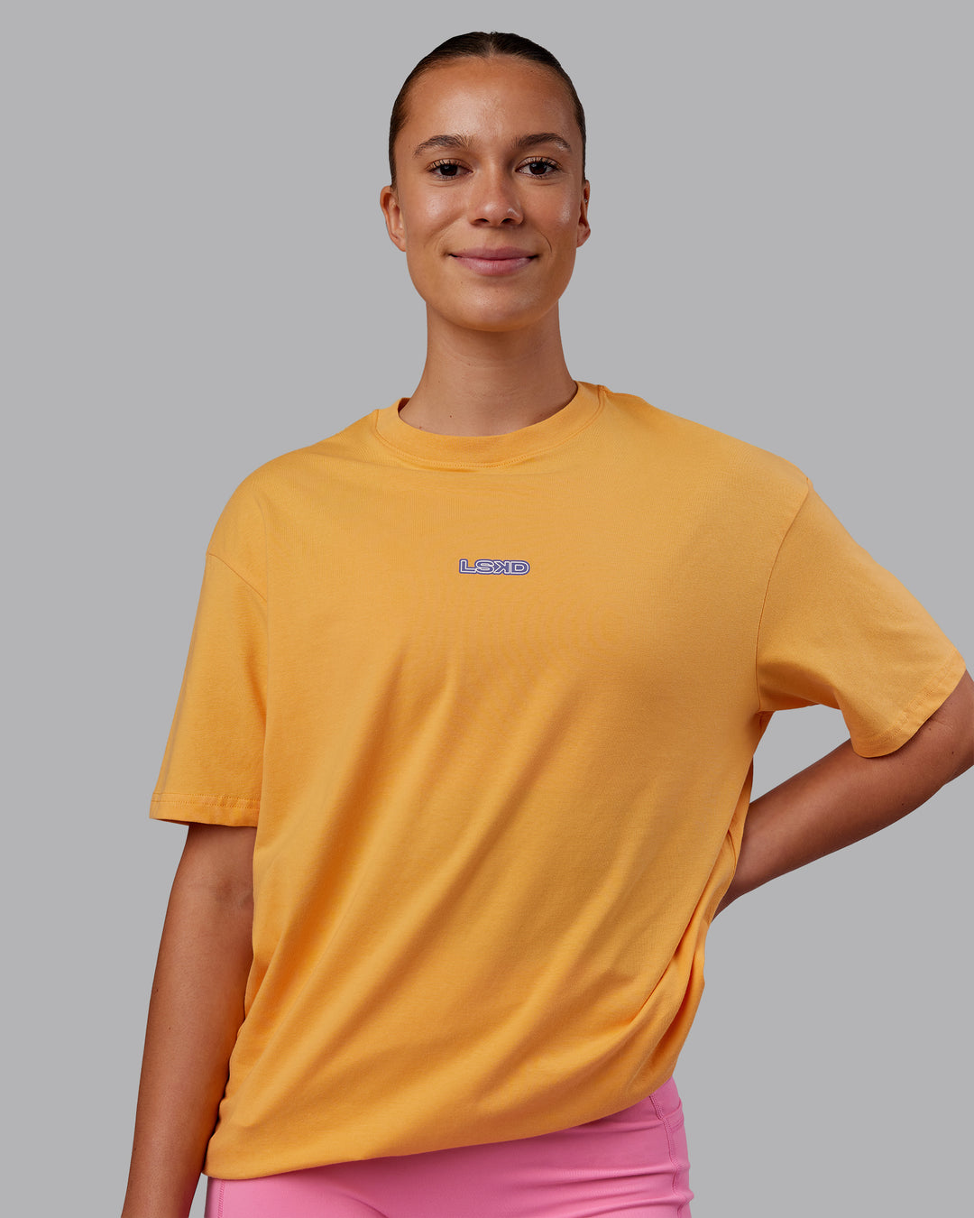 Woman wearing CFT BNE 25 FLXCotton Oversized Tee - Warm Apricot-Purple Opulence | Model:Charlize | Size:XS