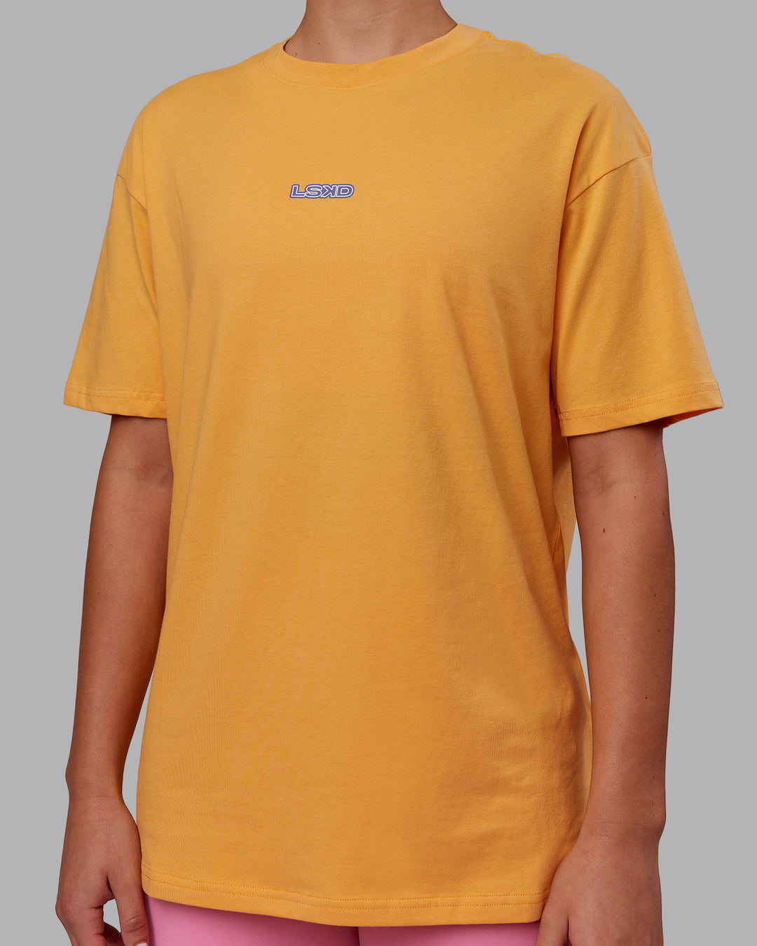 Woman wearing CFT BNE 25 FLXCotton Oversized Tee - Warm Apricot-Purple Opulence | Model:Charlize | Size:XS